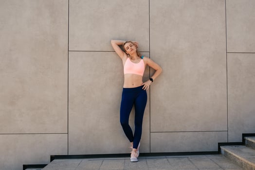 elegant sporty girl standing near the wall photo