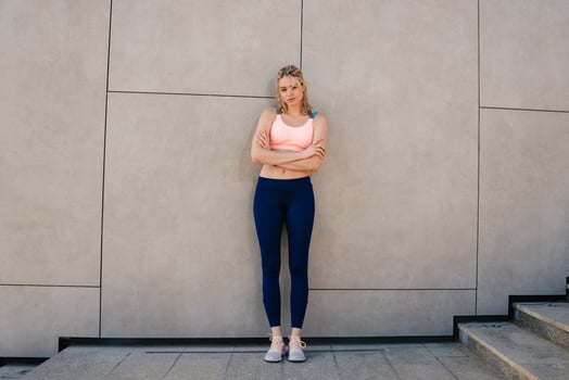 elegant sporty girl standing near the wall photo