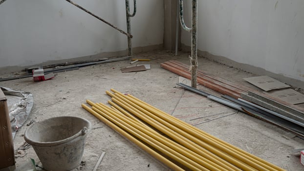 Yellow PVC pipe piled up in a construction building. along with other construction equipment placed inside the building. photo