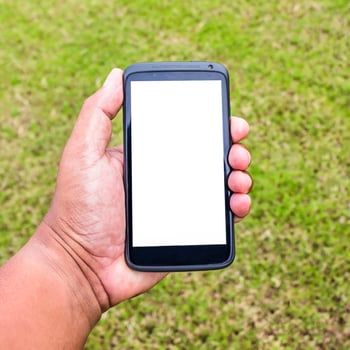 mobile on hand with green grass in garden photo