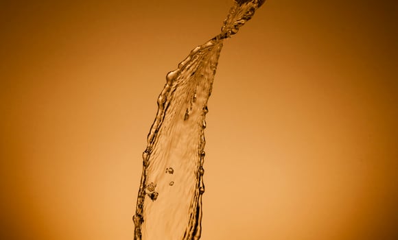 Falling water on a golden background photo