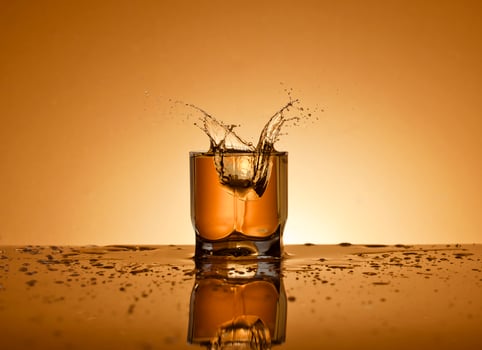 A glass of alcoholic drink on a golden background photo