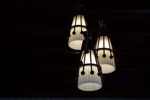 3 white pendant lamps on a black background to stand out and the beauty of the light. Soft and selective focus. photo