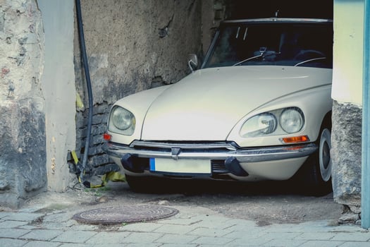 White Citroen vintage car parked in old town arch of a brick building side view photo