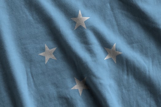Micronesia flag with big folds waving close up under the studio light indoors. The official symbols and colors in banner photo
