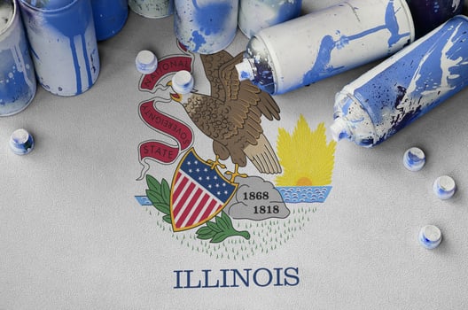 Illinois US state flag and few used aerosol spray cans for graffiti painting. Street art culture concept photo