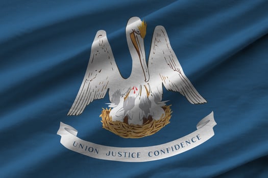 Louisiana US state flag with big folds waving close up under the studio light indoors. The official symbols and colors in banner photo