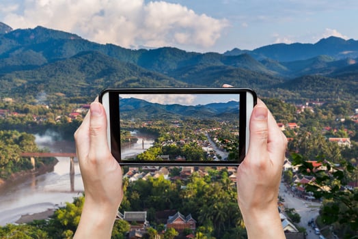 hand taking photo at viewpoint and landscape in luang prabang, Laos.