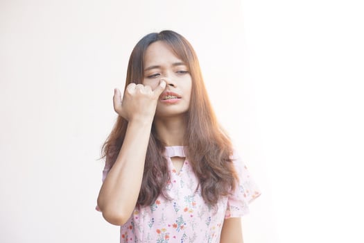 Asian woman gnawing her nose with her finger photo