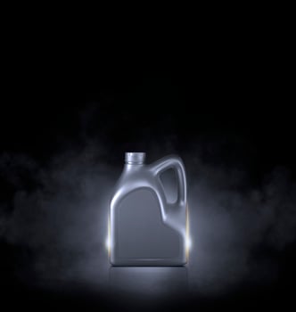 Grey bottle of engine oil on black background with smoke photo