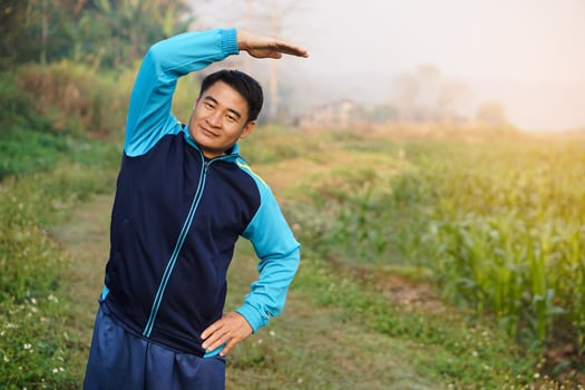 Handsome Asian man workouts  outdoor, body stretching. Warm up before or cool down after exercise. Concept, health care.  Sport.Creative activity. Give time for yourself. photo