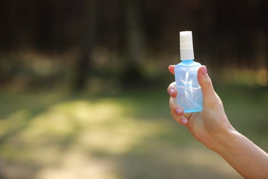 woman hand holding alcohol spray or anti bacteria spray outdoor to prevent spread of germs, bacteria and virus, quarantine time, focus on close up hands. coronavirus. copy space. selective focus photo