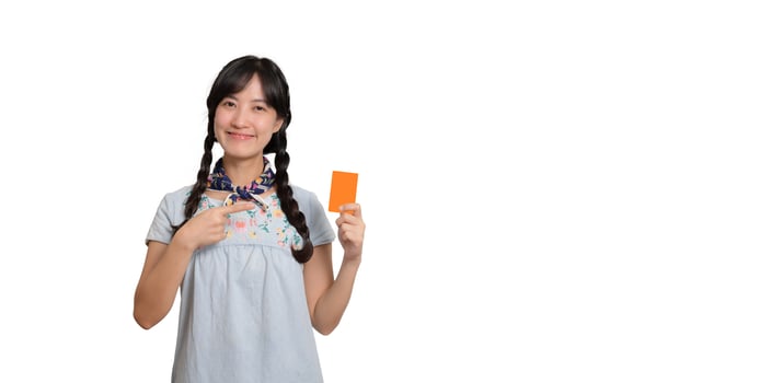 Portrait of beautiful happy young asian woman in denim dress holding credit card on white background photo