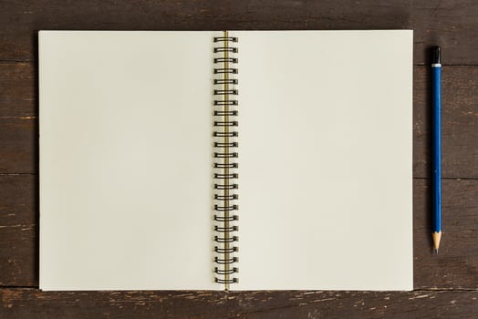 Brown open book with pencil on wood table photo