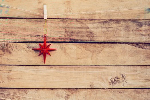 Ornamental red stars hanging on wooden for christmas background with space photo