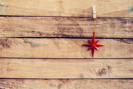 Ornamental red stars hanging on wooden for christmas background with space photo