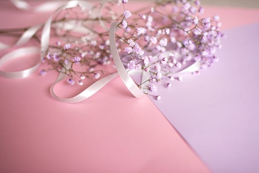 Pink tablet for text with a background of white flowers and ribbon photo