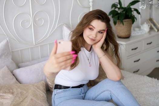A happy woman has a selfie. The girl looks into the phone camera and smiles. photo