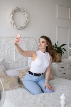 A happy woman has a selfie. The girl looks into the phone camera and smiles. photo