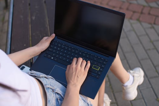 A girl holds a laptop on her feet photo