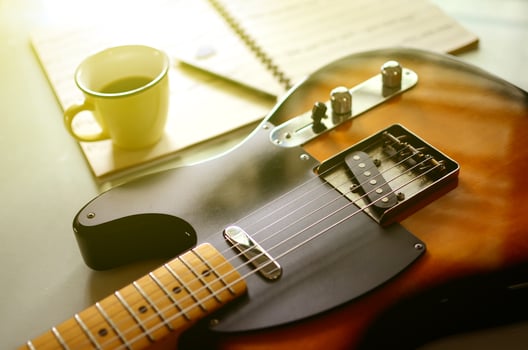 Electric guitar and  a cup of coffee on wood background photo
