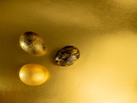 Easter eggs painted in gold and black on a glittering background for the holiday of bright easter photo