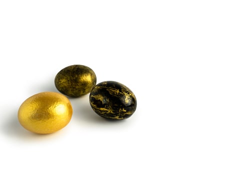 Easter eggs painted in gold and black marble colors on a white background. With the Easter holiday. Isolated photo