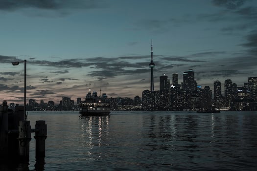 The Toronto shoreline at late sunset with a passenger ferry crossing between Centre Island and Toronto. photo
