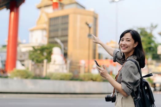 Young Asian woman backpack traveler enjoying China town street food market in Bangkok, Thailand. Traveler checking out side streets. photo