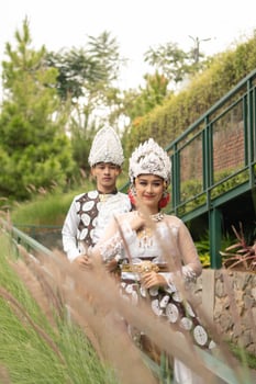 a couple in white clothes posing very intimately and intimately in a park photo