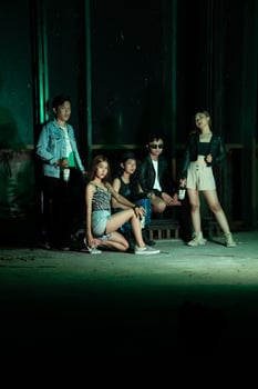 a group of teenagers in quirky clothes posing together as friends in a disco bar with a very cool expression photo