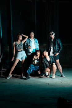 a group of women and men in modern clothes taking pictures together in a clubbing place while celebrating the new year photo