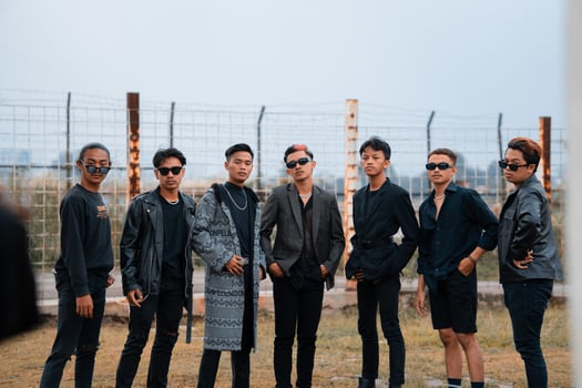 a group of teenage boys in black clothes posing very gallantly with their friends in a field photo