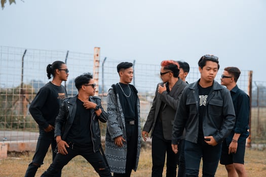 a group of teenage boys in black clothes posing very gallantly with their friends in a field photo