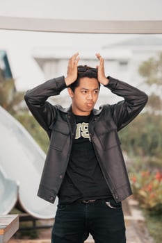 an Asian man is standing beside a cafe table in black leather clothes photo