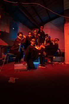 a group of delinquent teenagers wearing glasses and black clothes were sitting and gathering with their friends photo