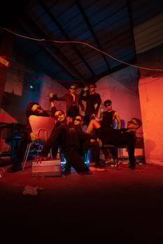 a group of thugs wearing dark clothes and glasses were having fun chatting with their friends in an old building photo