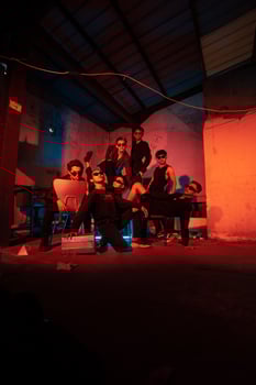 a group of thugs wearing dark clothes and glasses were having fun chatting with their friends in an old building photo