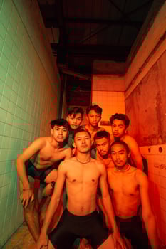 a group of men with open chests and short black pants posing together photo
