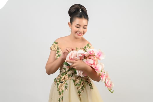 Young asian beautiful bride with orchid bouquet on white background photo