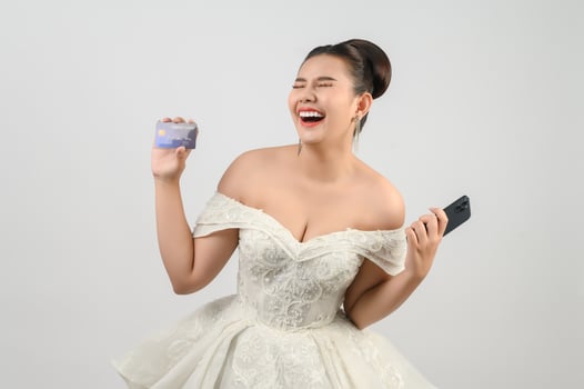 Young asian beautiful bride posting with credit card and smartphone in hand photo