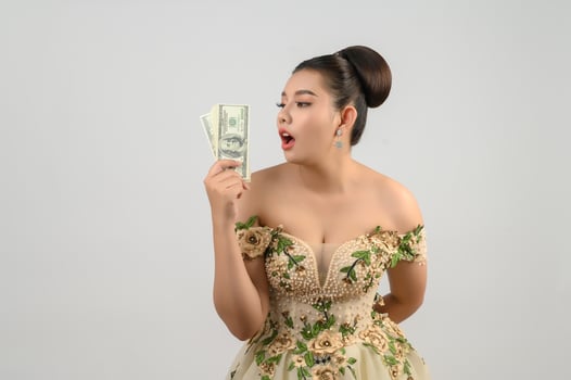 Young asian beautiful bride holding dollar bills in hand photo
