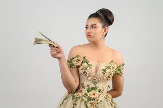 Young asian beautiful bride holding dollar bills in hand photo