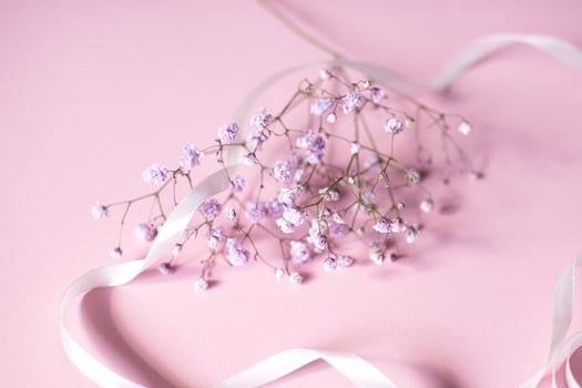 Pink tablet for text with a background of white flowers and ribbon photo