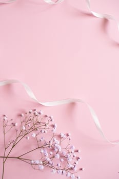Pink tablet for text with a background of white flowers and ribbon photo