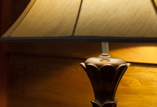 Elegant lamp in warm interior room,Turned On Old Lamp near the wooden wall photo
