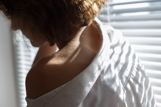 Sensual close up portrait of beautiful young lady relaxing at the window. female shoulder close up. hard shadows photo