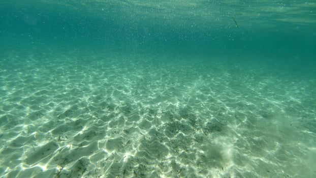 sand bottom underwater swimming in turquoise lagoon photo