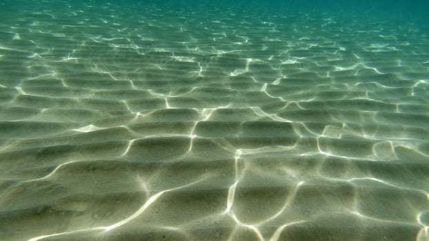 sand bottom underwater swimming in turquoise lagoon photo