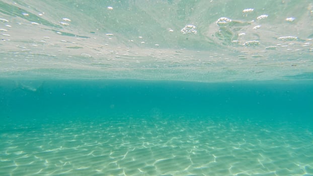 sand bottom underwater swimming in turquoise lagoon photo